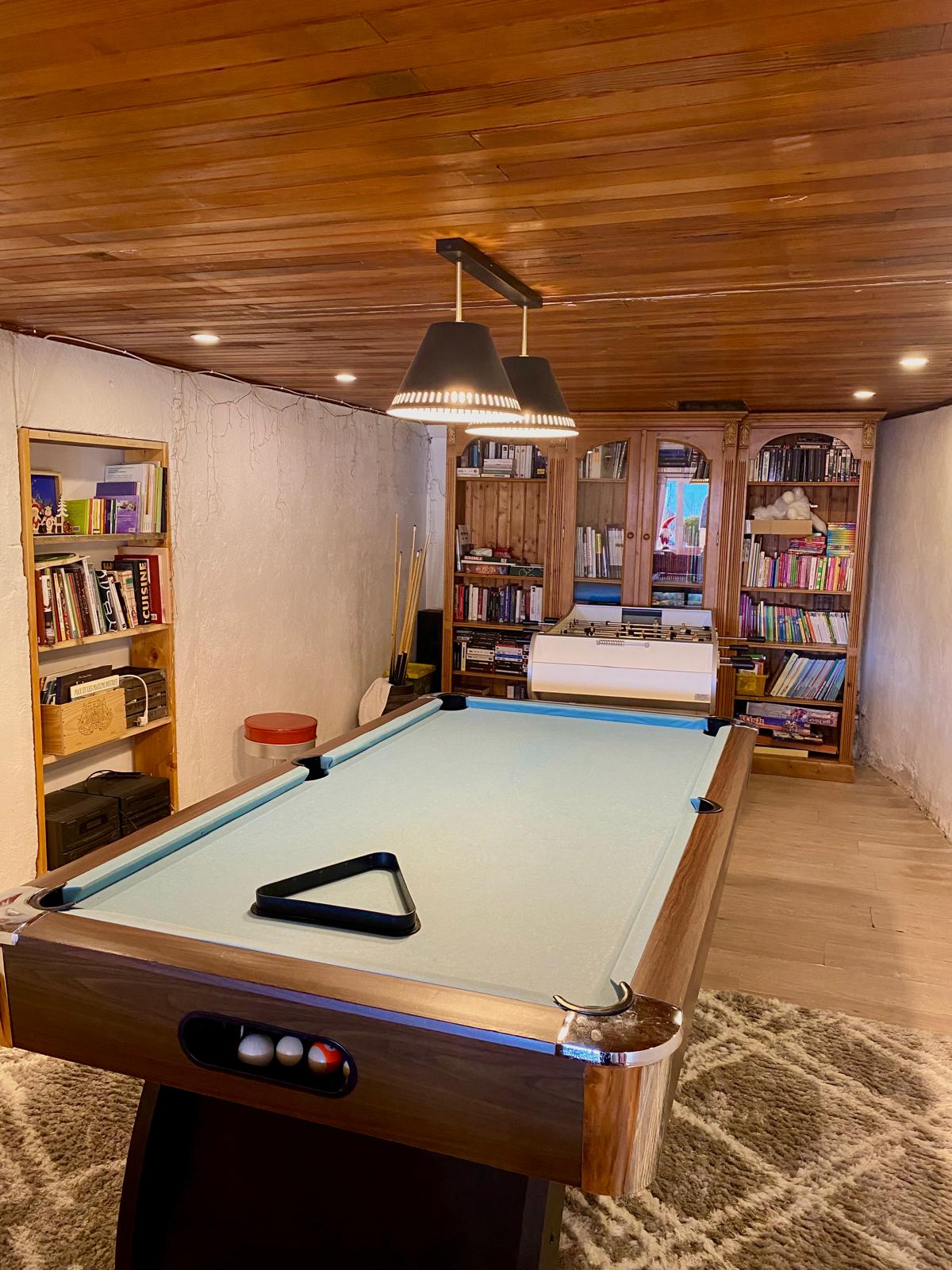 Table de billard et étagères de jeux de société