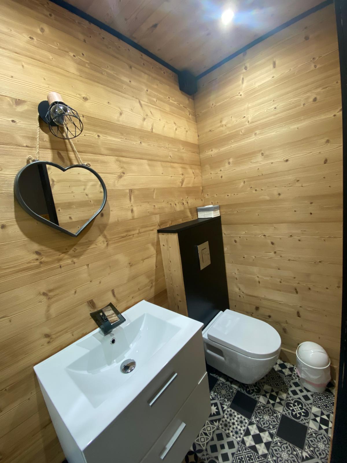 Lavabo et WC dans une salle d’eau au décor chalet