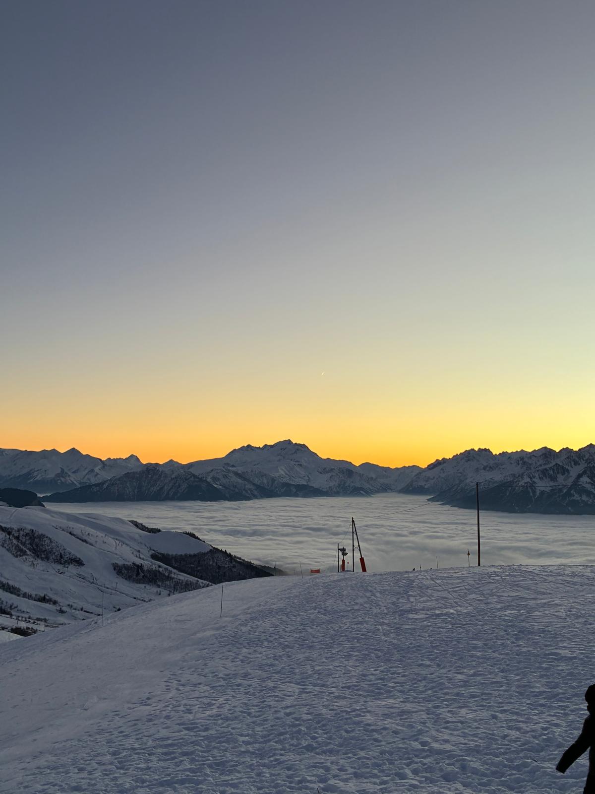 Piste damée au-dessus d’une mer de nuages au coucher du soleil