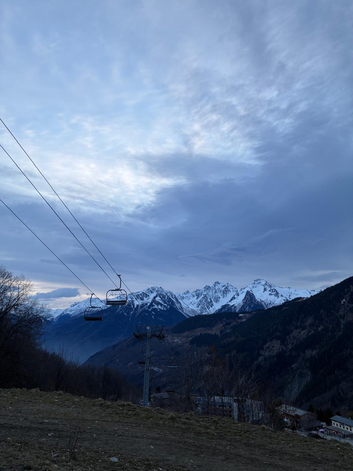 Télésiège au crépuscule face aux sommets enneigés